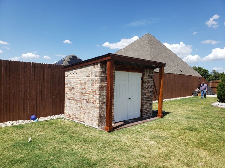 Brick storage building with a cedar pergola-style roof overhang