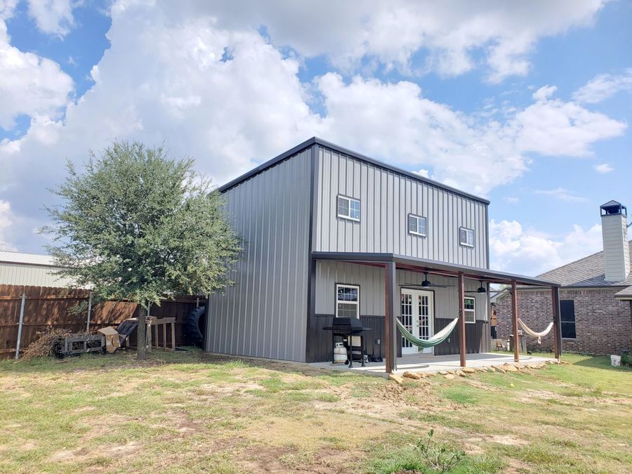 Finished metal-sided shop building with a loft and a covered porch